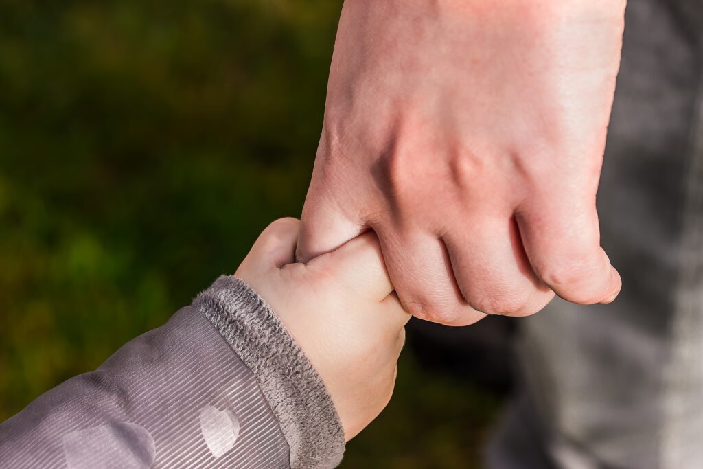 parent holding childs hand